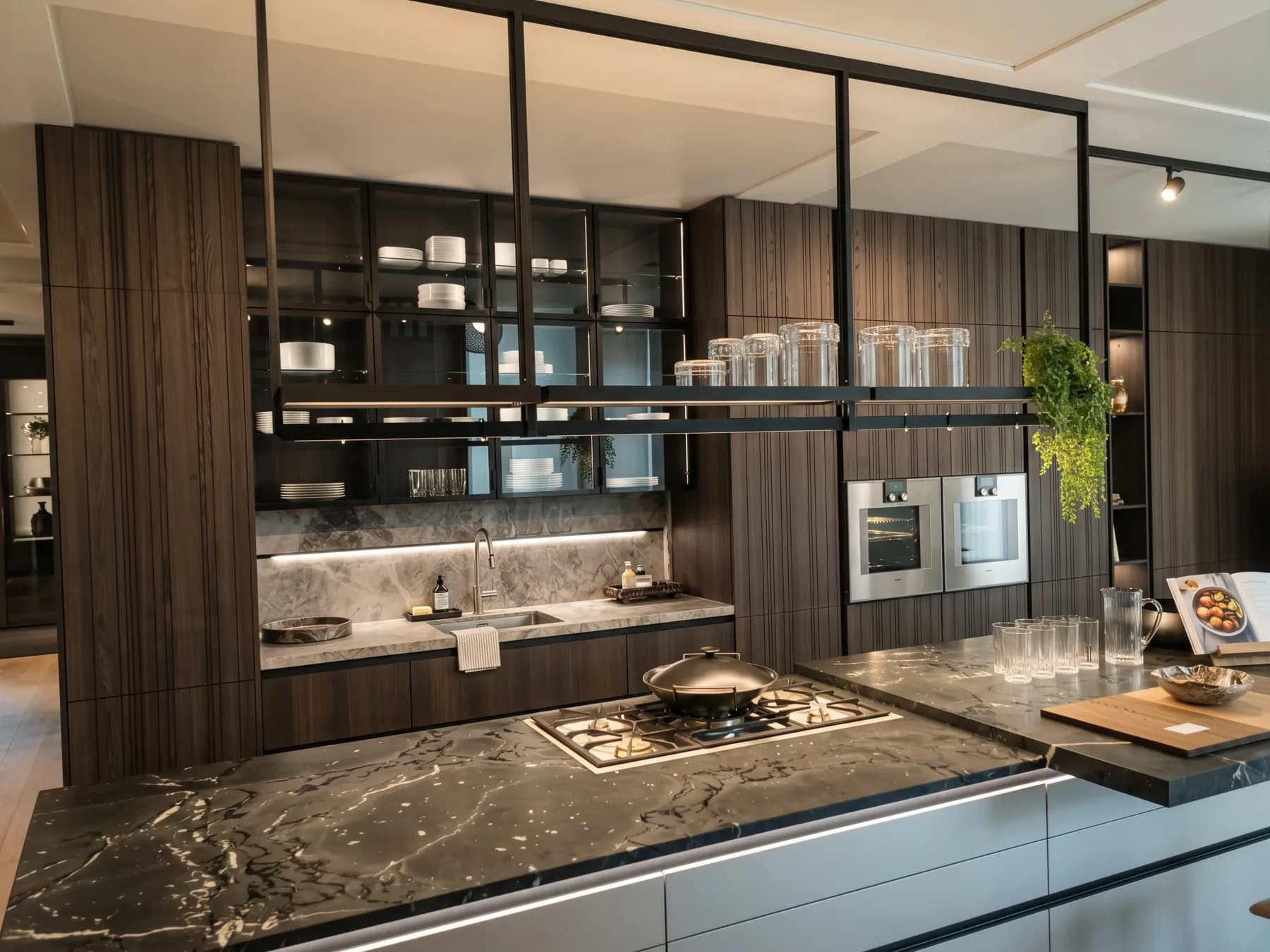 Black marble island worktop with an integrated hob and glass shelving