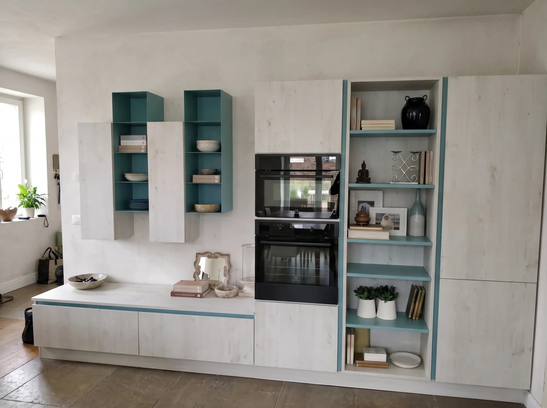 Whitewashed oak wall units with teal interior shelving