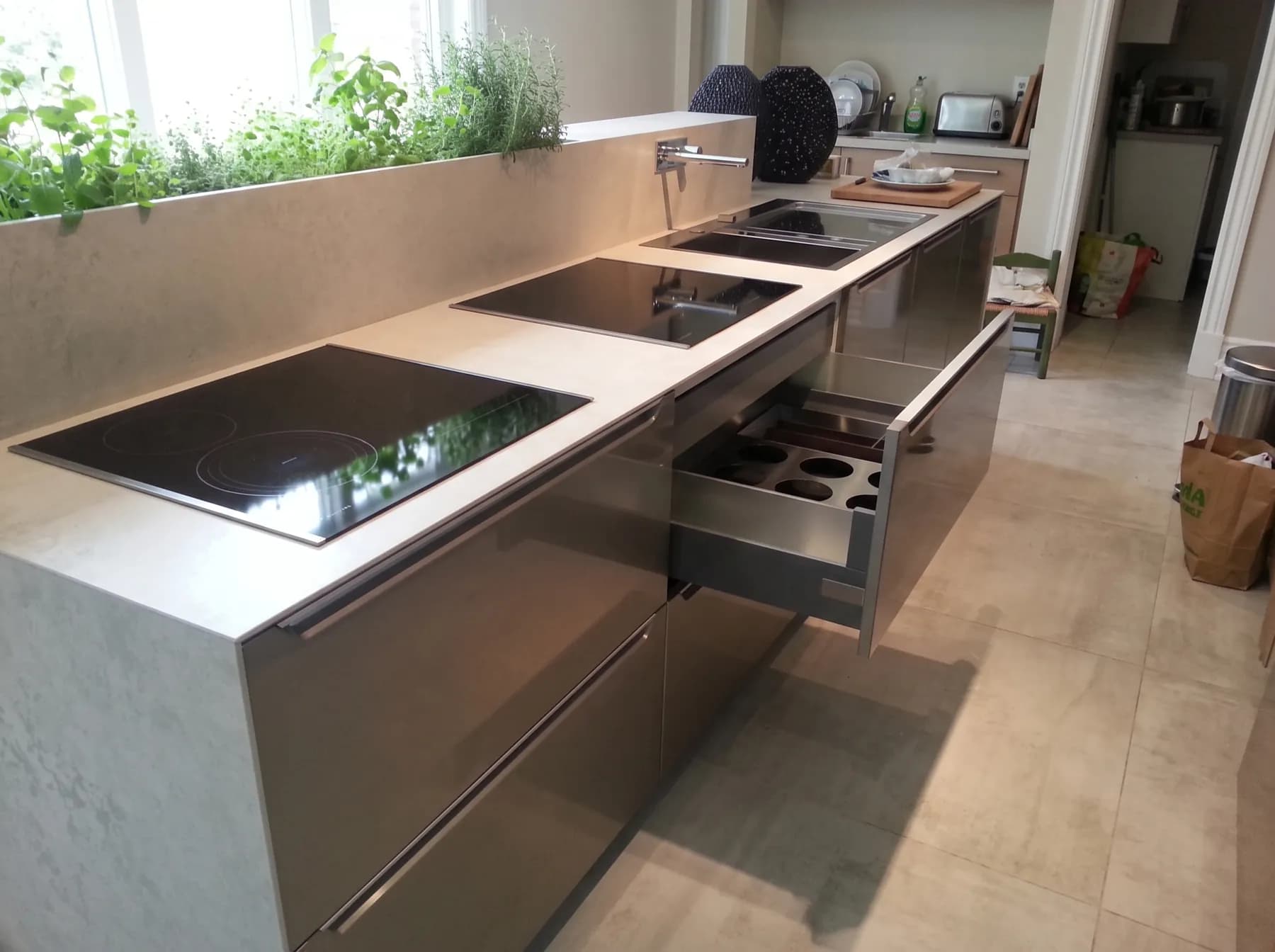 Brushed steel handle-less island with induction hobs set flush