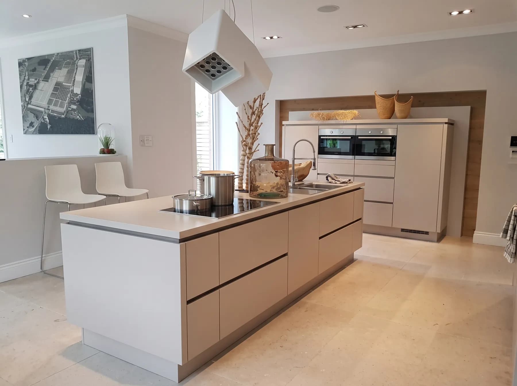 Handle-less off-white kitchen island with induction hob
